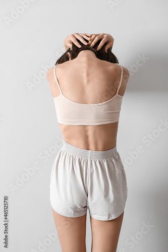 Young skinny woman on light...