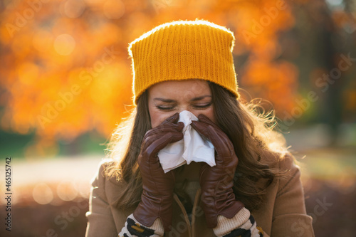 elegant female in beige coat and orange hat photo