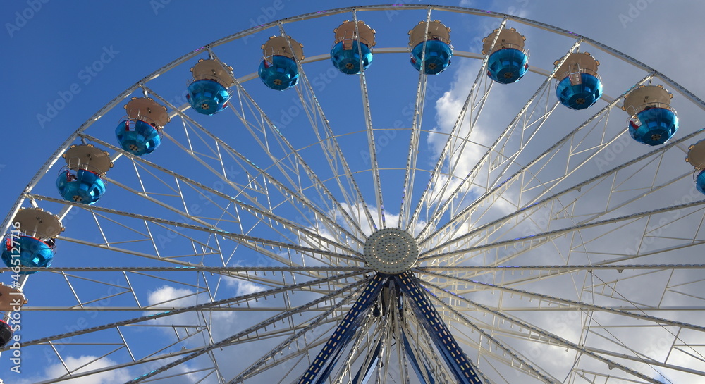 Riesenrad vor strahlend blauem Himmel mit weißen Wölkchen Riesenrad vor strahlend blauem Himmel mit weißen Wölkchen