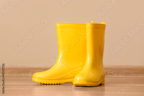 Pair of yellow rubber boots against color background © Pixel-Shot