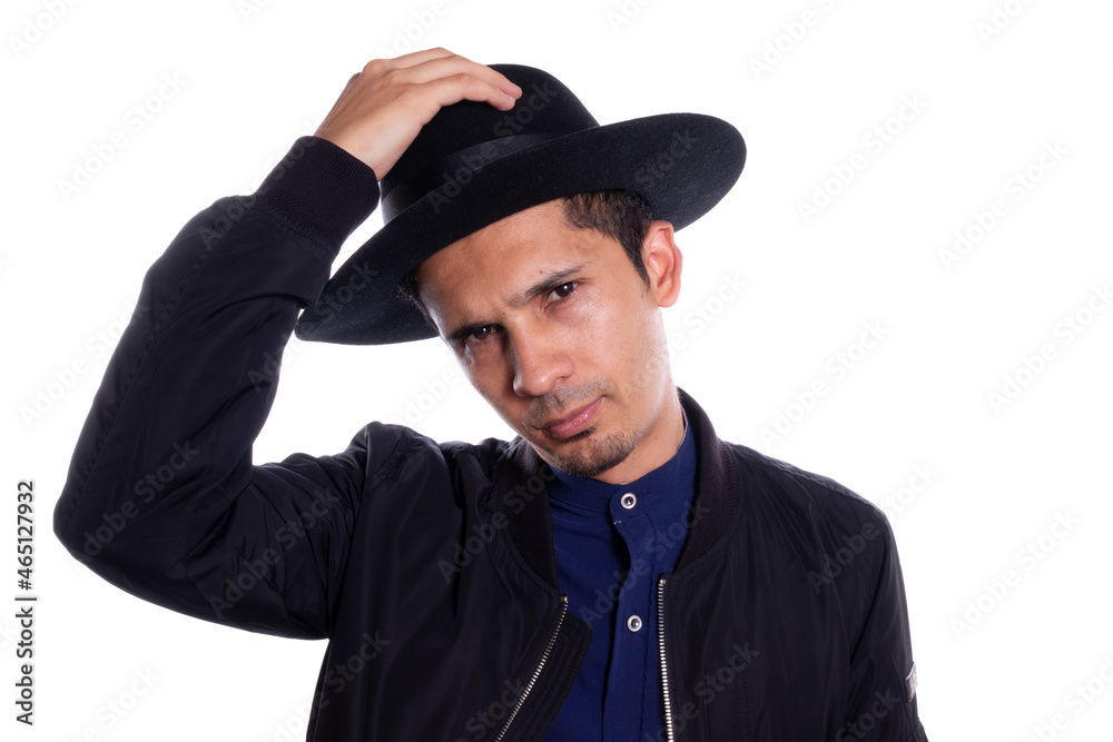 Man putting on black hat on white background. Young Latino man wearing hat. Man putting on black hat on white background. Young Latino man wearing hat.