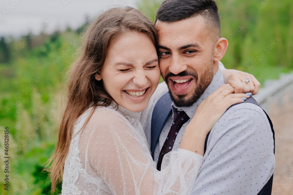 the bride and groom cuddling and laugh in nature. romance in the relationship the bride and groom cuddling and laugh in nature. romance in the relationship