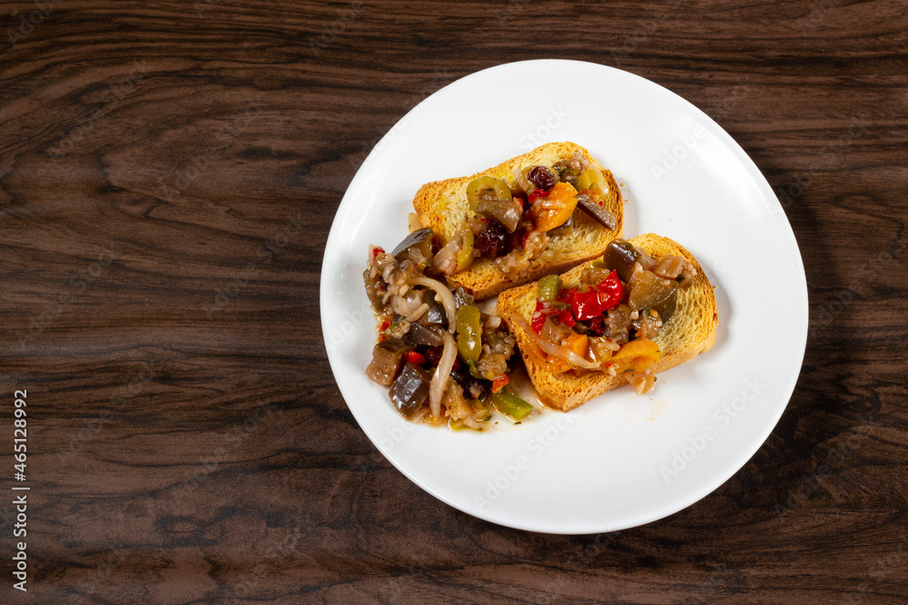 Eggplant appetizer antipasti made with yellow pepper, onion, raisin, and olive oil. Top View Eggplant appetizer antipasti made with yellow pepper, onion, raisin, and olive oil. Top View