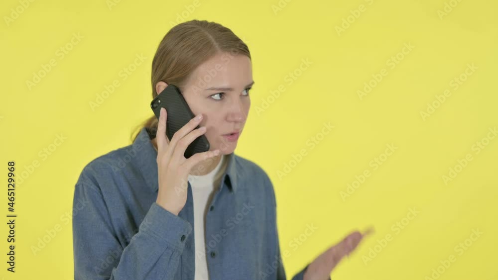 Young Woman Talking Angry on Phone on Yellow Background Young Woman Talking Angry on Phone on Yellow Background