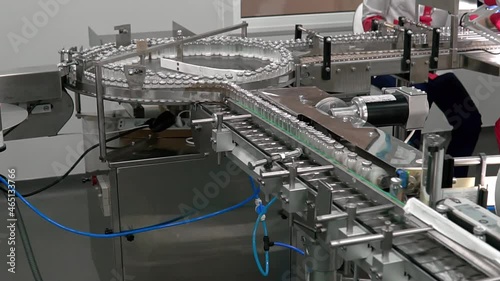 Vaccine Mass Production Laboratory. Medicine bottles pharmaceutical factory. Automated production of ampoules with medicine vaccine. Empty glass bottles on automatic production line machine conveyor.