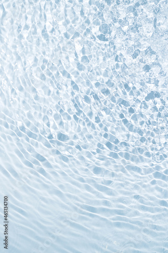 Fototapeta Naklejka Na Ścianę i Meble -  The background of blue water from drops spreads in different directions in interesting stains and stripes. Beautiful background vertical concept