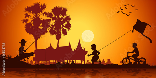 Country life of Asia boy play kite,ride bicycle and fishing on sunset time,silhouette style