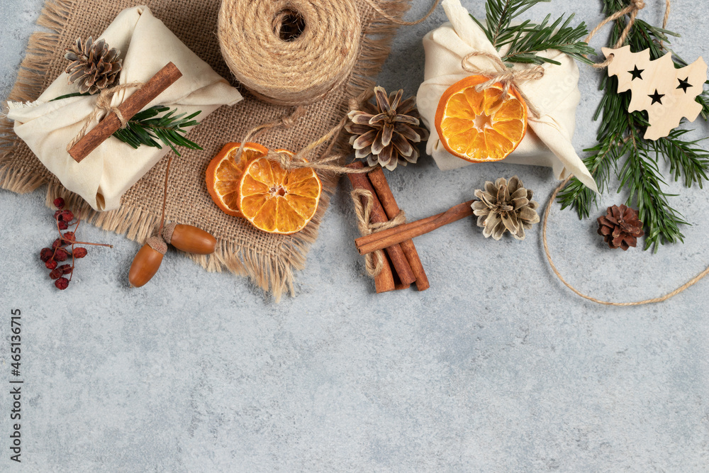 Zero waste christmas concept. Packed in natural fabric gifts and decorations from natural materials on gray table, top view, copy space Zero waste christmas concept. Packed in natural fabric gifts and decorations from natural materials on gray table, top view, copy space