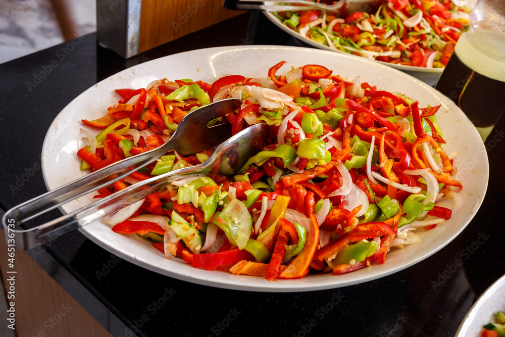 A mix of cucumbers and bell peppers is on a large plate. A mix of cucumbers and bell peppers is on a large plate.