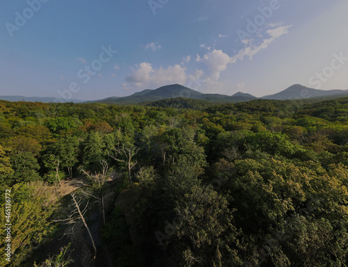 Mountains overlooking the green forest against the blue sky. photo from a quadrocopter