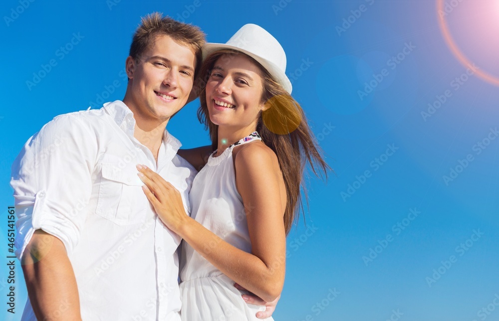 Beautiful woman with a man walking on the beach. Young couple enjoying honeymoon after marriage Beautiful woman with a man walking on the beach. Young couple enjoying honeymoon after marriage