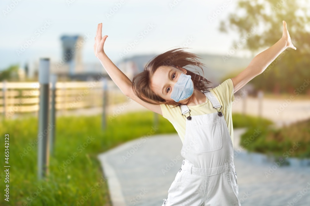 Portrait of funny child in medical protective face mask having fun
