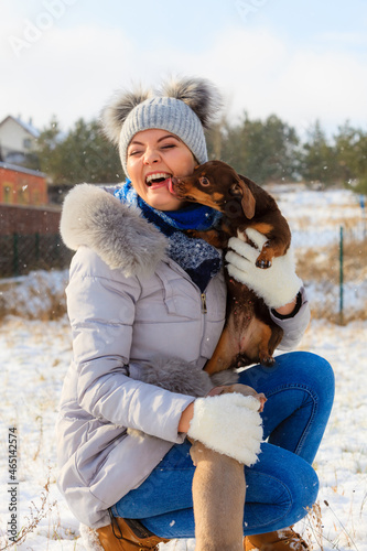 Canvas Print Woman playing with dogs during winter