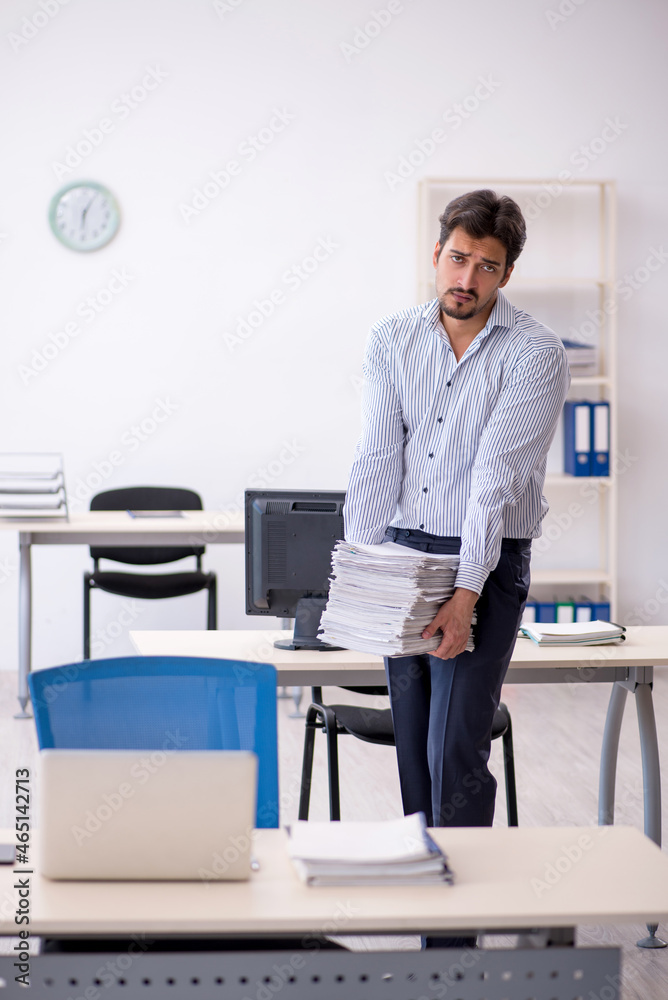Young male employee and too much work in the office Young male employee and too much work in the office