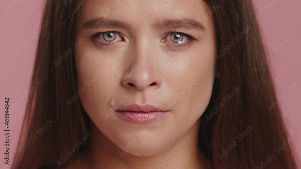 Unhappy Lady Crying Looking At Camera Wiping Tears From Sad Face Posing Over Pink Studio Background. Sadness And Frustration, Negative Emotions Concept. Cropped Shot Unhappy Lady Crying Looking At Camera Wiping Tears From Sad Face Posing Over Pink Studio Background. Sadness And Frustration, Negative Emotions Concept. Cropped Shot