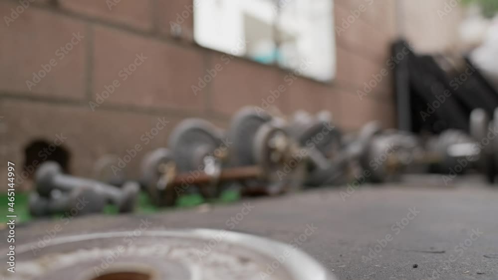 This slow motion video shows a weight plate dropping to the gym floor and bounding towards the viewer. This slow motion video shows a weight plate dropping to the gym floor and bounding towards the viewer.