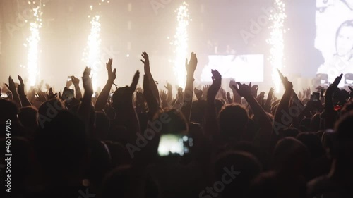 Crowd cheering on a music festival. Hands in the air. Colorful illuminations and smoke photo