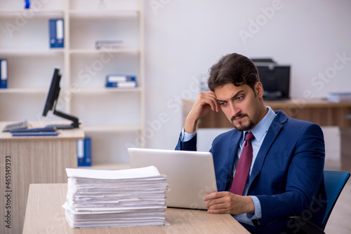 Young businessman employee and too much work in the office