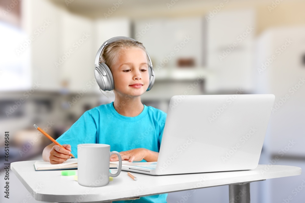 Smiling little child in headphones have a video call distant class using a laptop. Education concept. Back at school after covid-19 quarantine. Smiling little child in headphones have a video call distant class using a laptop. Education concept. Back at school after covid-19 quarantine.