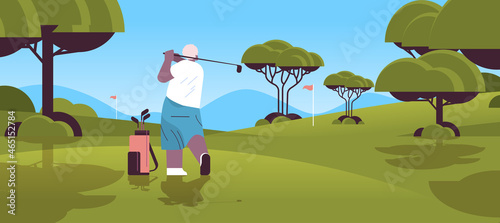 senior woman playing golf on green golf course aged african american player taking a shot active old age concept