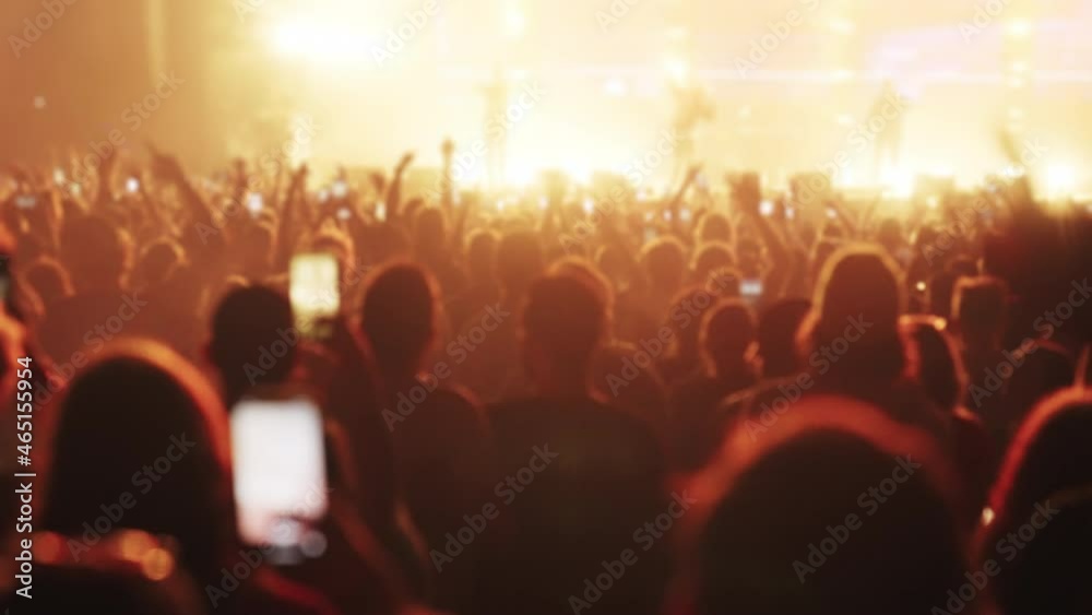 Crowd cheering on a music festival. Focus on dancing people recording with smart phones