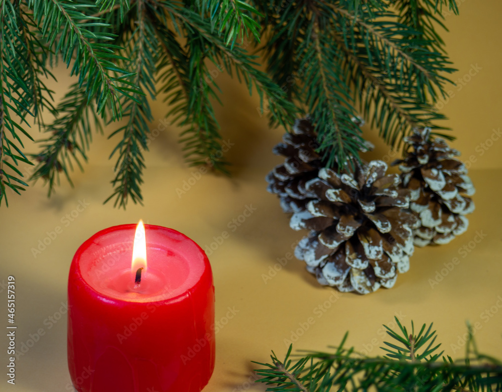 New Year's card, decorations. Candle, cones and fir branches on a beige background. New Year. Christmas New Year's card, decorations. Candle, cones and fir branches on a beige background. New Year. Christmas