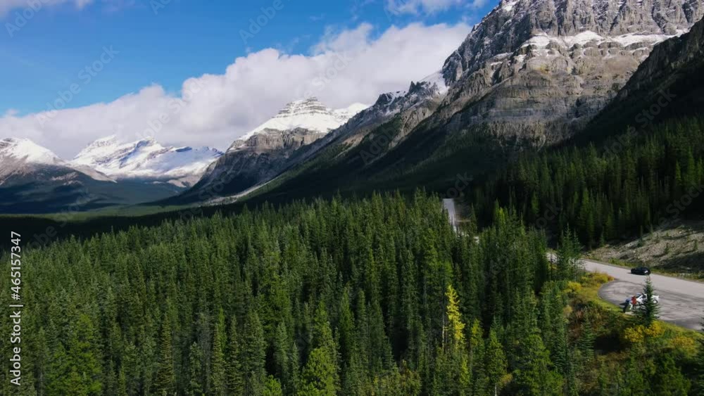 Ariel View of Road in Mountains and Forest with green Pine Woods in Banff National Park. Scenic view on Sunny day in Rocky Mountains in Canada. Road trip.