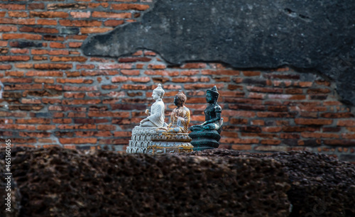 Aytthaya, Thailand, 22 Aug 2020 : Three small buddha statue and wall made by old red brick background at Wat Ratchaburana  in The Historical Park of Ayutthaya Thailand. Selective focus. photo