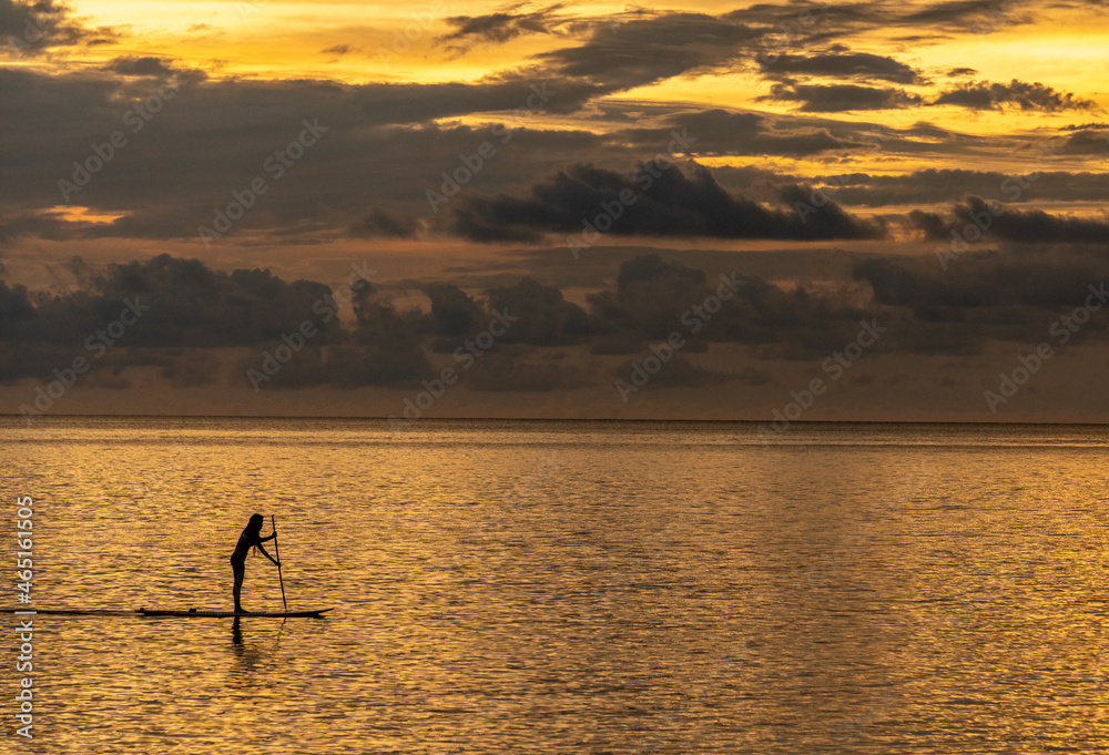 Stand-up paddle board rider at sunset off the coast of Koh Chang island in Thailand