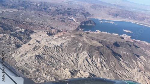 Looking out the window of an airplane as it flys over the Hoover Dam.