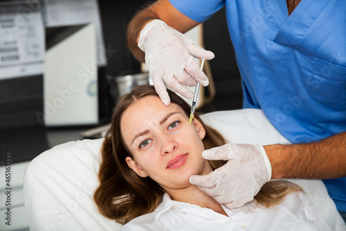 Woman getting beauty facial injections for rejuvenate and tighten skin at beautician office, concept of aesthetic medicine