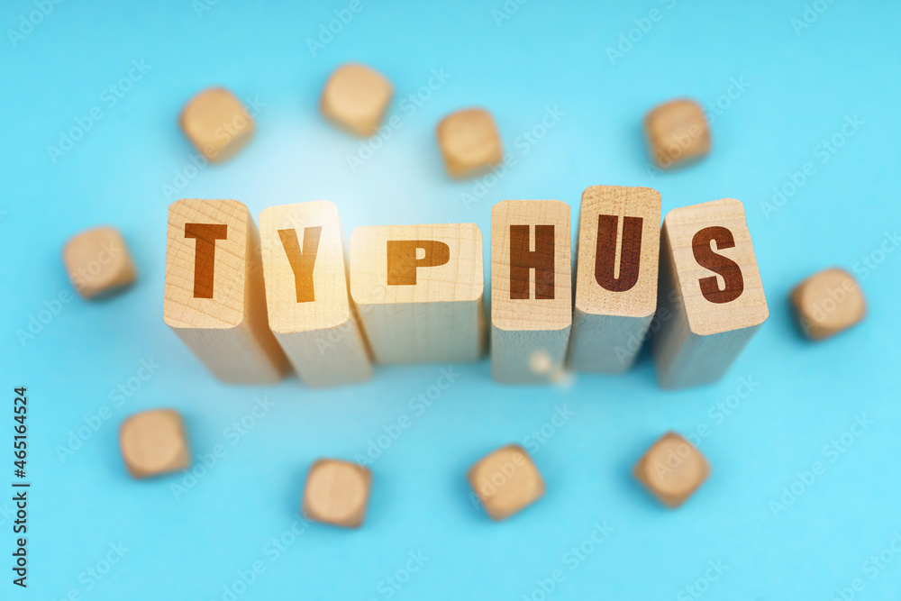On a blue background, wooden cubes and Jenga with the inscription - TYPHUS On a blue background, wooden cubes and Jenga with the inscription - TYPHUS