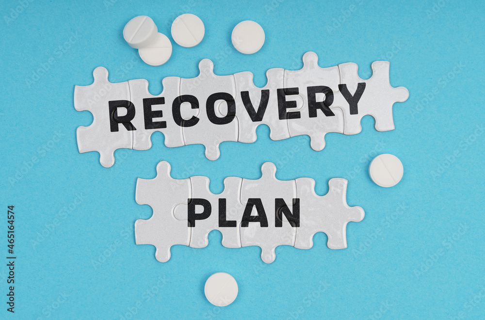 Fototapeta premium On a blue background pills and puzzles with the inscription - RECOVERY PLAN