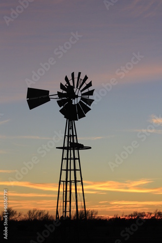 windmill at sunset with a colorful sky north of Hutchinson Kansas USA out in the country.
