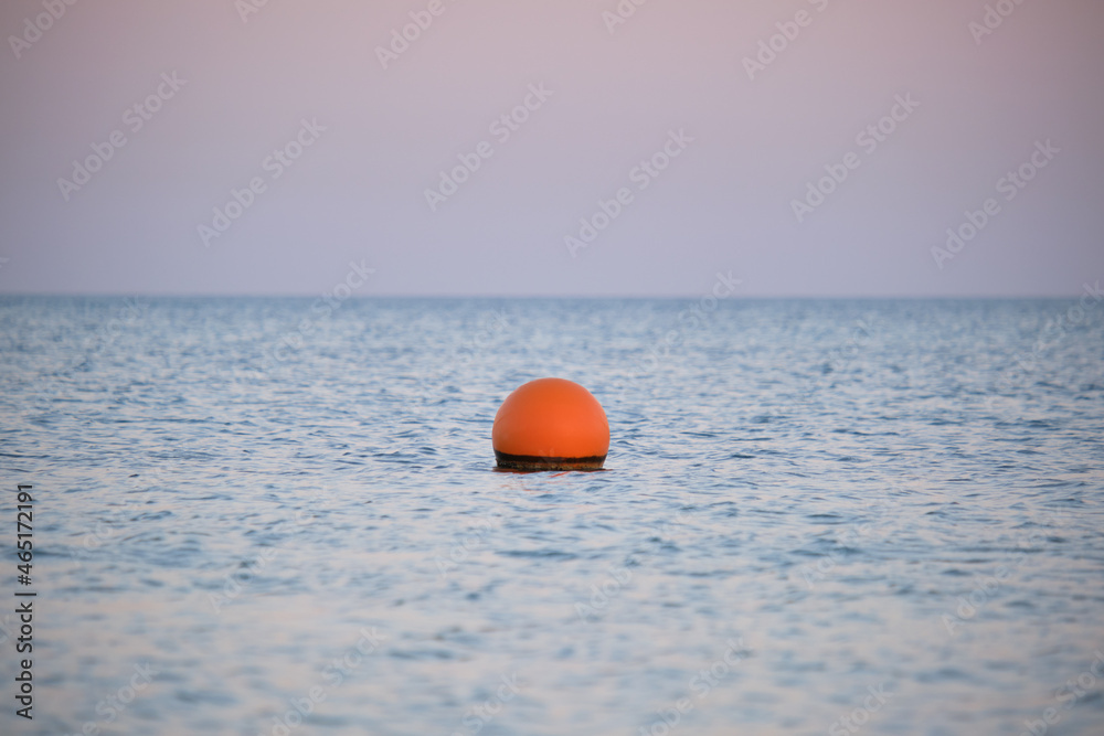 Yellow buoy floating on sea surface as marker for swimming restriction in deep water at tropical resort. Human life safety concept. Yellow buoy floating on sea surface as marker for swimming restriction in deep water at tropical resort. Human life safety concept.