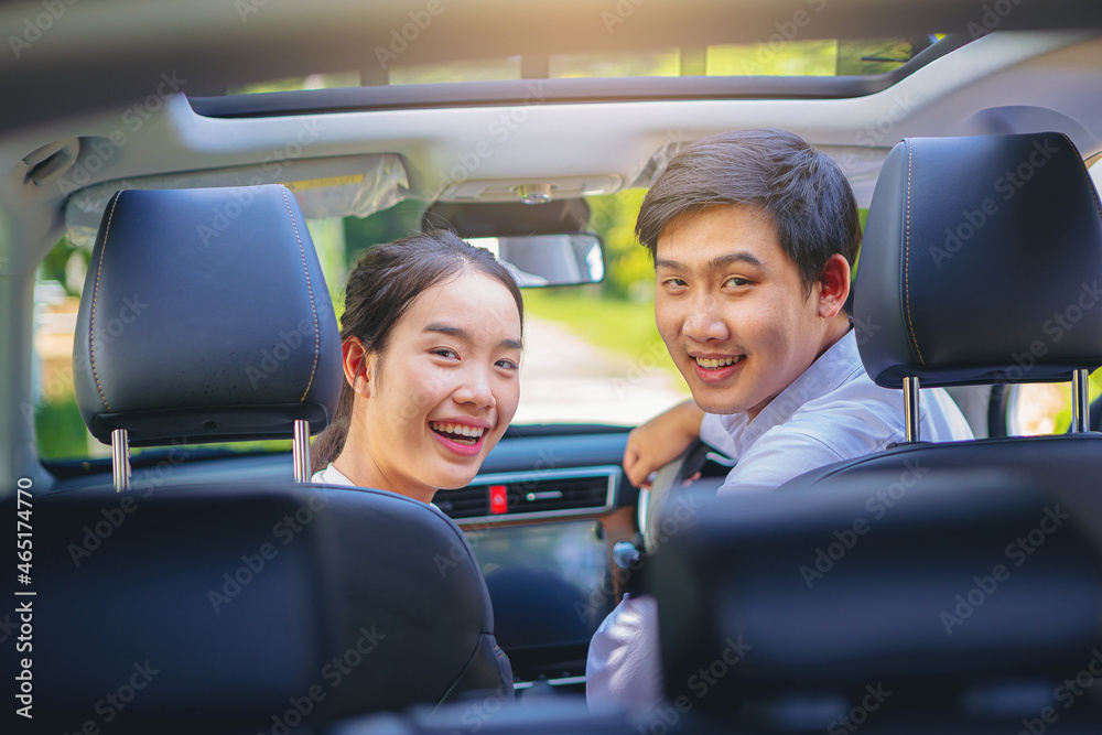 Young couples sitting at car seat and looking back in new car together. travel and lifestyle concept	