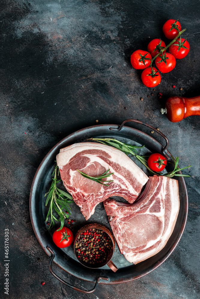 pork, beef, chop on a bone. fresh raw meat with spices and rosemary. vertical image. top view. place for text