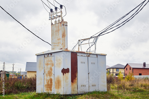 A large transformer booth with wires in a country village.
