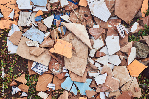 Multicolored fragments of ceramic tiles with different patterns on the ground.
