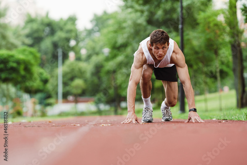 Young white runner working out on running track outdoors