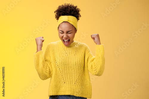 Foto Excited thrilled beautiful young girl student yelling happily clench fists victo