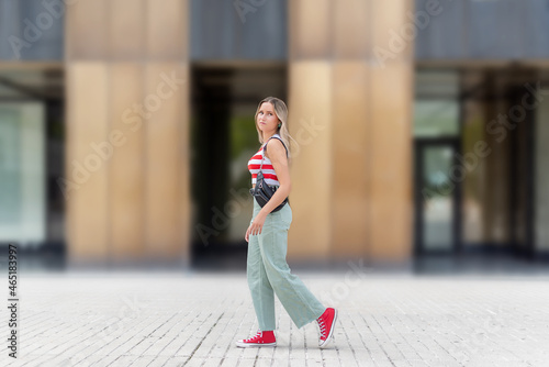 Young blonde woman with handbag walking in the street