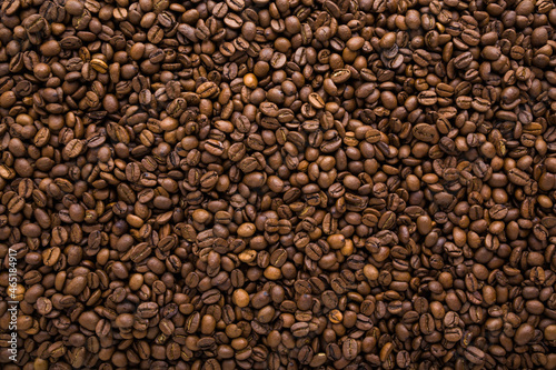 Fresh dark brown coffee beans background. Closeup. Empty place for text. Top down view.