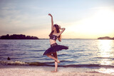 Passionate And Sensual Japanese Ballet Dancer in Black Tutu And Silver Crown Posing Near Seashore During Ballet Pas in Summertime in Dance Pose Outdoor.