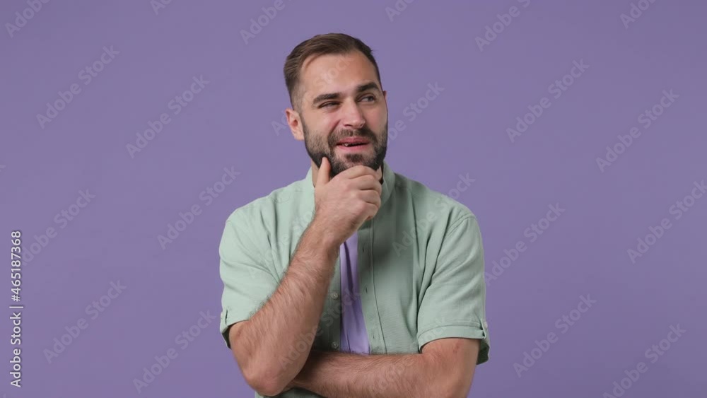 Excited insighted smart proactive puzzled pensive young bearded man 20s wears mint shirt looks around thinks comes up with ideas raised finger isolated on plain light purple background studio portrait Excited insighted smart proactive puzzled pensive young bearded man 20s wears mint shirt looks around thinks comes up with ideas raised finger isolated on plain light purple background studio portrait