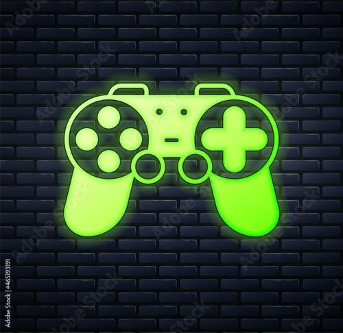Glowing neon Gamepad icon isolated on brick wall background. Game controller. Vector