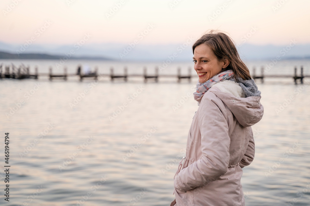 Smiling mid adult woman standing near sea during weekend Smiling mid adult woman standing near sea during weekend