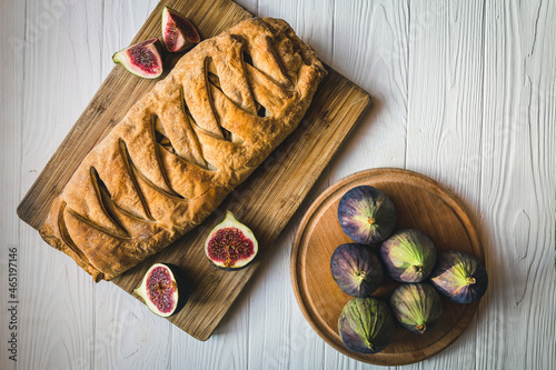 Rustic pie with figs and apples on a wooden board. Homemade delicious fig cake.