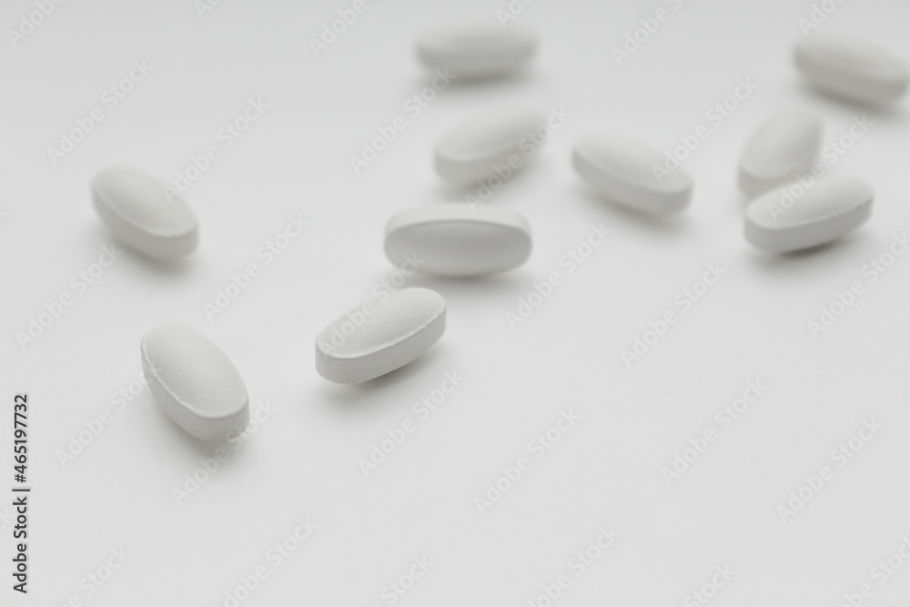 white tablet pills on white blurred background, selective focus white tablet pills on white blurred background, selective focus