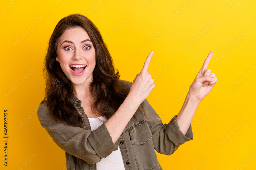 Portrait of attractive cheerful glad girl demonstrating copy space ad new offer isolated over bright yellow color background Portrait of attractive cheerful glad girl demonstrating copy space ad new offer isolated over bright yellow color background